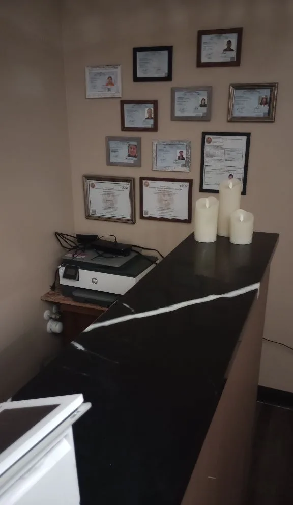 Wall of therapist licenses and certifications at Healing Hands Clearwater