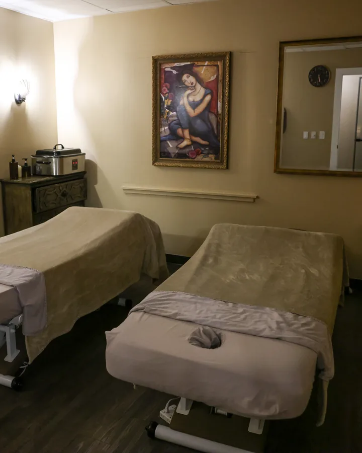 Private couples suite with two massage tables, framed art and mirrors